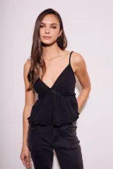 Blusa negra de algodón con breteles finos, escote en V con detalle de encaje y diseño con volados en el ruedo.
