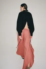 Pantalón confeccionado en lino 100%, de tiro medio con cintura elástica ajustable mediante cordones y bajo redondeado con aberturas laterales.