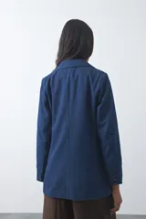 Blazer de jean color celeste con silueta recta y corte sastrero. Presenta solapas clásicas, cierre frontal con botón forrado, bolsillos con tapa y detalle de botones forrados en los puños.
