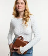 Blusa de manga larga, color blanco, con cuello redondo y textura de punto calado con diseño geométrico.