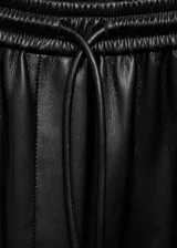 Pantalon de efecto piel con cintura elástica y lazo ajustable. Presenta un diseño de corte recto tipo jogger con bolsillos laterales.