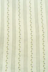 Conjunto infantil compuesto por una blusa verde agua con volados en los hombros y botones frontales, un pantalón de corte recto con estampado de rayas verticales y una colita para el pelo a juego.