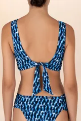Top de bikini con estampado abstracto en tonos azules y negros, con escote halter y hebilla dorada en el centro.