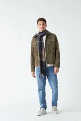 Campera de gamuza color verde oliva, con cuello medio, bolsillos tipo cartera y cierre frontal con botones.