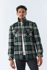 Sobrecamisa de algodón a cuadros con interior de corderito, cierre con botones, bolsillos tipo cartera y logo en goma. El modelo usa talle M.