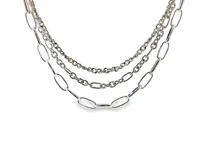 Collar en capas de metal plateado, compuesto por una combinación de cadenas de diferentes estilos, incluyendo eslabones ovalados grandes y eslabones finos entrelazados.