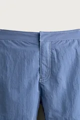 Short de baño azul con pespuntes en contraste, bolsillos frontales, cintura ajustable con trabillas laterales y cierre frontal.