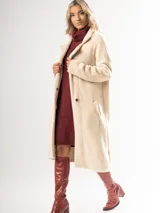 Tapado largo color camel confeccionado en lana escarada elastizada. Diseño clásico con cuello solapa y corte recto. Fabricado en Italia.