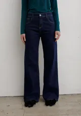 Pantalón de jean negro de corte recto y tiro medio, con cierre frontal de botón y cremallera, y bolsillos laterales y traseros.