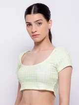 Crop top de punto color verde claro con estampado a cuadros blancos, escote redondo y mangas cortas.