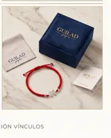Pulsera de hilo rojo tejida en macramé con dijes centrales de dos figuras de nenas en plata 925 y terminaciones con esferas de plata.