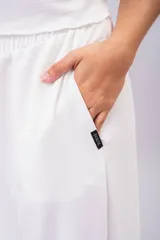 Pantalón palazzo negro de corte wide leg, confeccionado en tela ligera con caída y cintura elastizada de tiro medio-alto.
