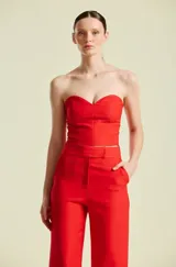 Top de mujer strapless color rojo, de corte estructurado estilo corsé con escote en corazón, confeccionado con costuras verticales que aportan definición a la silueta.