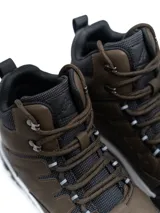 Bota de trekking de caña alta modelo Alpes, confeccionada en ecocuero marrón con refuerzos negros en puntera y talón. Cuenta con cuello acolchado, ojalillos metálicos, cordones bicolores y suela dentada antideslizante con entresuela blanca.