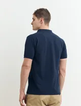 Chomba verde con cuello polo y tapeta de dos botones.