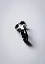 Anillo negro de acero quirúrgico hipoalergénico con línea plateada en el centro.