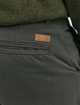 Pantalón de corte clásico confeccionado en sarga de algodón con elastano. Presenta bolsillos delanteros inclinados y bolsillos traseros de ribete.