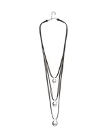 Collar de diseño triple compuesto por tres tiras de cuero marrón oscuro, cada una con un dije en forma de gota o esfera irregular con baño de plata.