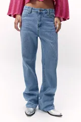 Pantalón de jean azul medio con tiro medio y apliques de strass plateados.