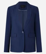 Blazer de sastrería color azul marino, con solapas clásicas, cierre frontal de un solo botón con detalle metalizado y bolsillos simulados. Confeccionado en una mezcla de viscosa y poliéster, presenta un corte recto y estructurado.