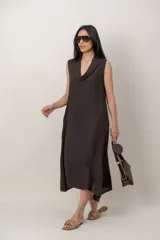 Vestido midi de lino color verde militar, sin mangas, con escote buche y bolsillos laterales, de corte relajado y fluido.