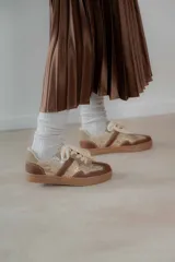 Championes urbanos de diseño acolchado, combinando tonos marrones, beige y detalles metalizados con textura. Cuentan con cordones al tono y suela de goma color caramelo.