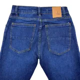 Pantalón de jean azul marino, corte chupín, con cinco bolsillos y talle 30.