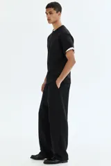 Pantalón de jogging negro de felpa pesada, corte holgado con cintura elástica ajustable mediante cordón y bolsillos laterales.