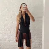 Top halter negro con escote pronunciado en V, faja ancha fruncida en la cintura y tiras largas colgantes.
