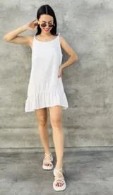 Vestido corto blanco de breteles finos con volados en el ruedo.