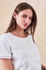 Remera de algodón de corte clásico y entallado, con cuello redondo y mangas cortas con detalle de costura decorativa en el borde.