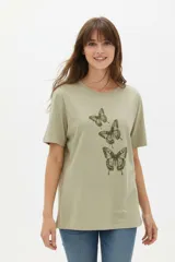 Remera de manga corta color blanco, de corte holgado con cuello redondo a la base y estampado frontal en tono bordó de un gato y un ovni en un paisaje desértico.