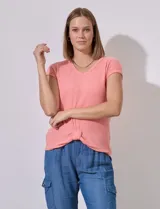 Remera color salmón en tejido rib con escote en V, manga corta y terminación anudada en el ruedo.