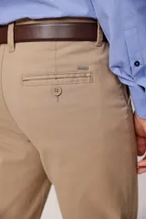 Pantalón de vestir color beige, confeccionado en algodón con spandex. Corte recto, con bolsillos laterales y traseros. Se ajusta a la cintura con cinturón de cuero trenzado en tonos azul y beige.