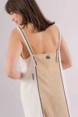 Vestido largo de lino con diseño bicolor en beige y crudo, escote en V y breteles regulables. Presenta detalles de bordados geométricos en el frente y tajos laterales.