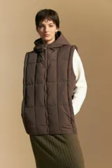 Chaleco acolchado de nylon color negro, con diseño capitoneado, capucha integrada y cierre frontal con tirador metálico.