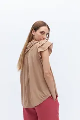 Blusa blanca de lyocell y algodón, con escote fruncido con volados y lazos.