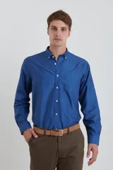 Camisa azul con microestampado de lunares blancos, de corte clásico, con cuello abotonado y manga larga.