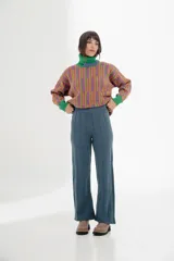 Pantalón tejido azul con corte acampanado y textura acanalada vertical.