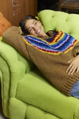 Sweater tejido a mano en lana merino color marrón con cuello redondo y diseño de rayas horizontales de colores en la parte superior. De calce holgado con cuello a la base y puños.