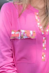Camisa fucsia de viscosa con detalles pintados a mano en cobre, rosa y blanco en cuello, bolsillos y puños. Presenta mangas largas, cuello en V con escote abotonado y bolsillos frontales con solapa.