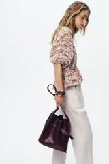 Pantalón tobillero color beige, con cintura elástica ajustable con cordones, bolsillos delanteros y falsos bolsillos con solapa en la espalda.