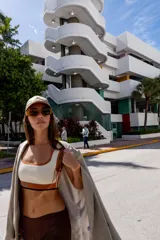 Top deportivo azul con contorno y tirantes blancos, banda inferior blanca con logo en rojo y borde inferior rojo.