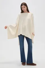 Poncho crudo de tejido de punto con diseño holgado y sin mangas.