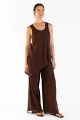 Pantalón ancho de color marrón, con pretina elástica, bolsillos laterales y aberturas en los bajos. Confeccionado en tejido fluido.
