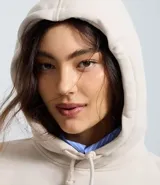 Buzo oversized color beige con capucha ajustable y bolsillo canguro. Presenta un estampado frontal estilo college con el texto "ROMA ITALY 1987" en negro y detalles en azul. Tiene puños y bajo ajustados.