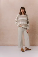 Pantalón de jean color beige, de corte wide leg y tiro alto, con diseño de pierna amplia y largo al tobillo.
