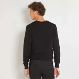 Sweater negro de punto liso con cuello en V y mangas largas.