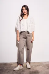 Blusa negra de algodón peinado con calce oversize, escote en V, mangas tres cuartos abullonadas y detalles de encaje y bordados en el frente y mangas.