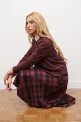 Falda midi a cuadros en tonos bordó, negro y gris, con diseño de corte evasé y caída fluida.